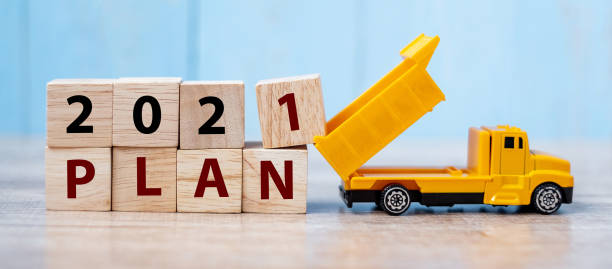 istock 2021 Plan cube blocks with miniature truck or construction vehicle. New Start, Vision, Resolution, goal, industrial, Warehouse and happy New Year concept 1283111658