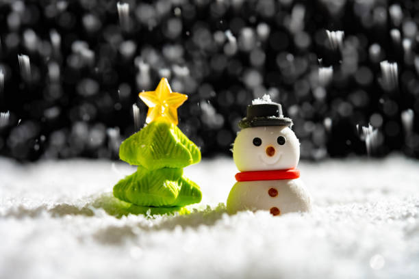 snowman and Christmas tree in a snowing night