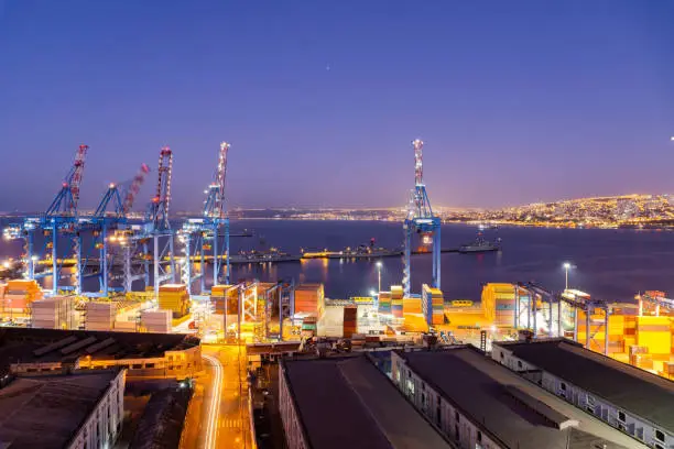 Long exposure of port of Valparaíso at night with cranes and containers