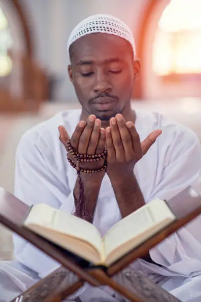 Photo of Religious black Muslim man praying inside the mosque