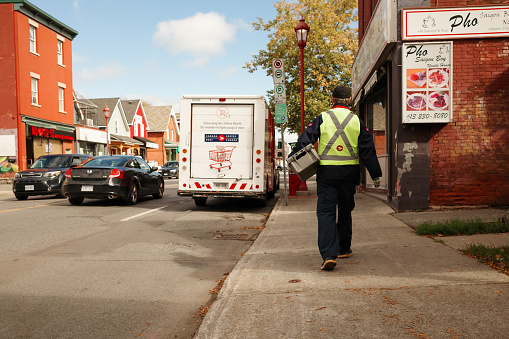 Ottawa, Ontario, Canada - October 8, 2020: A Canada Post worker returns to a delivery van in Ottawa.
