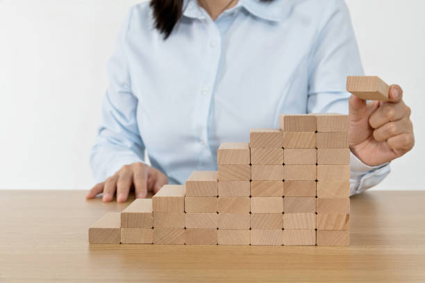 istock Woman hand building stairs with blocks 1283119159