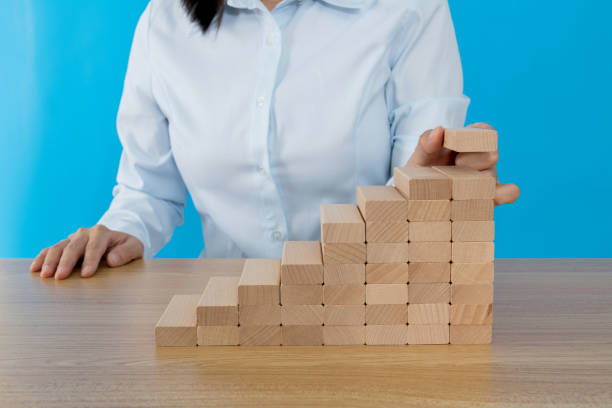 istock Woman hand building stairs with blocks 1283119160