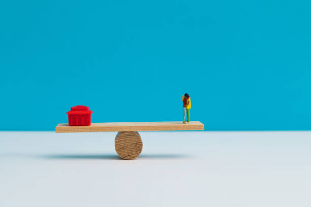 istock Seesaw with house model and couple figurine 1283122098
