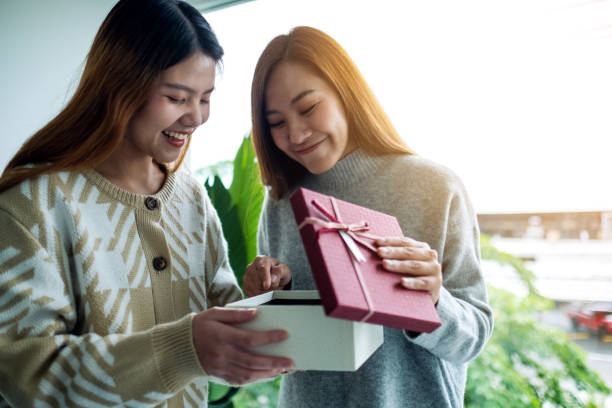 istock young asian women opening a gift box together 1283127503