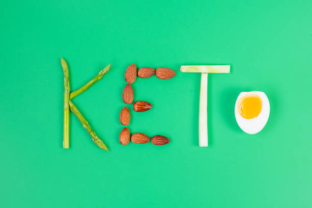 keto anordnung von bio-spargel, mandel, brokkoli und gekochtem ei auf grünem hintergrund. gewichtsverlust, ,gesunde ernährung, ketogene ernährung, low carb und vegetarisches konzept - cheese plant stock-fotos und bilder