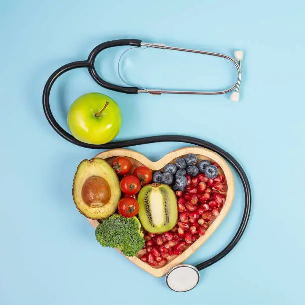 fruit and Vegetable; Blueberries, cherry Tomatoes, Avocado, Broccoli, Kiwi and green apple on blue background. weight loss, nutrition, Healthy food, Dieting and vegetarian concept