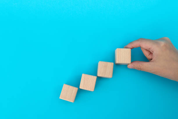 istock Wooden blocks as a staircase on blue background 1283130990