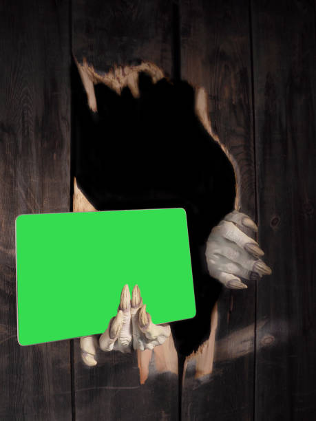 istock Zombie hand through hole cracked in rustic wood.Halloween theme 1283132776