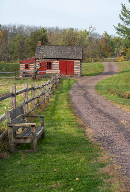 istock idyllic country lane winds past an empty bench and a log cabin. 1283133034