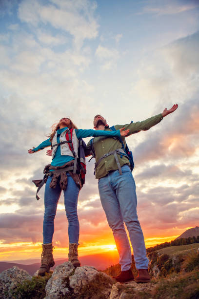 istock Couple on Top of a Mountain Shaking Raised Hands 1283133080