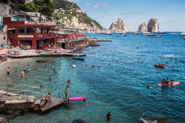 Capri, Italy - August 27 2020: Marina Piccola Harbor and Beach on Capri Island, Italy, with Tourists Bathing