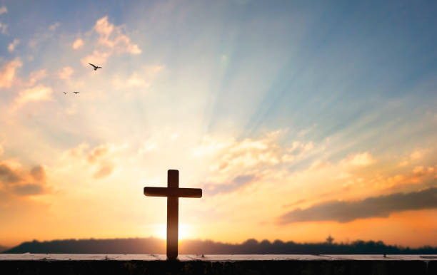 istock Religious concept: Silhouette cross on  at sunset background 1283134933