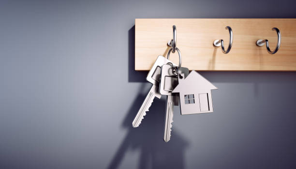 Hanging House Keys with Keyring House Keys with Key Ring hanging on wooden Board home ownership stock pictures, royalty-free photos & images