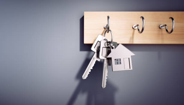 Hanging House Keys with Keyring House Keys with Key Ring hanging on wooden Board key stock pictures, royalty-free photos & images