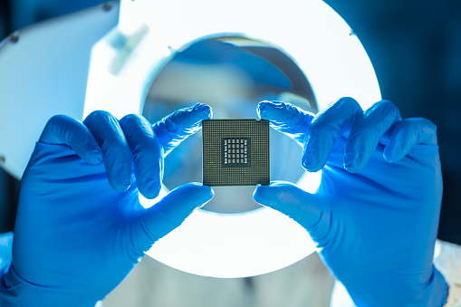 Engineer analyzing computer chip in laboratory