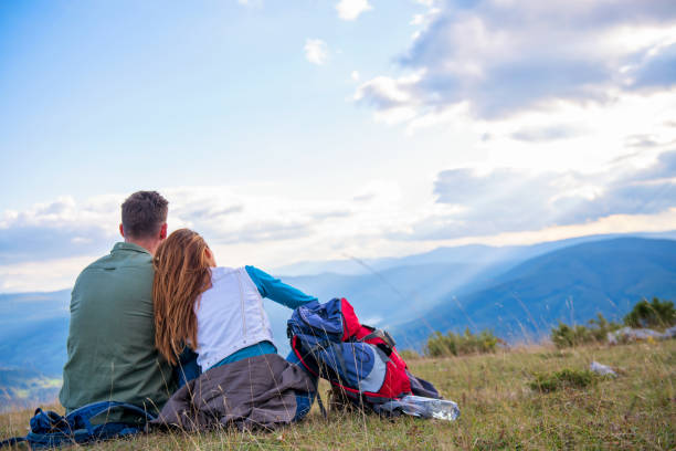 istock Couple Sitting On A Rock Resting During Hike 1283140056