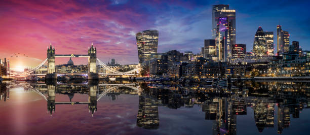 The lit urban skyline with City of London and Tower Bridge just after sunset The lit urban skyline with City of London and Tower Bridge just after sunset time with reflections in the river Thames, United Kingdom central london skyline stock pictures, royalty-free photos & images