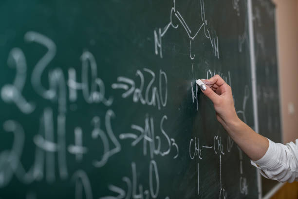 istock teacher hand holding pointer and showing formulas in chemistry lesson on blackboard 1283143267