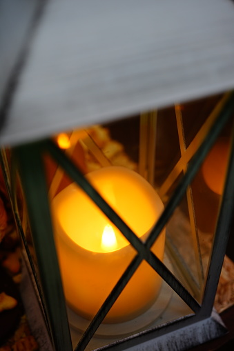 Close-up of Christmas lantern with candle light at dusk.