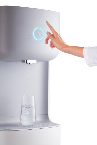 Modern technology concept. New water cooler format. Touch panel with a luminous indicator. A hand reaches for the cooler. Technological design. stock photo