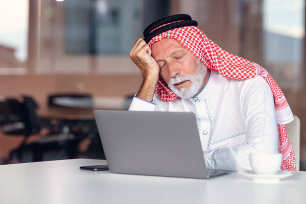 el hombre de negocios árabe es aburrido en la oficina moderna. cansado. - headscarf islam senior adult east fotografías e imágenes de stock
