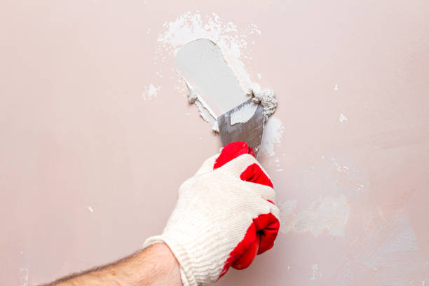 istock Puttying, sealing cracks with gypsum plaster using a spatula. Damaged wall repair. 1283147406