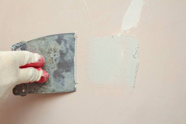 istock Puttying, sealing cracks with gypsum plaster using a spatula. Damaged wall repair. 1283147422