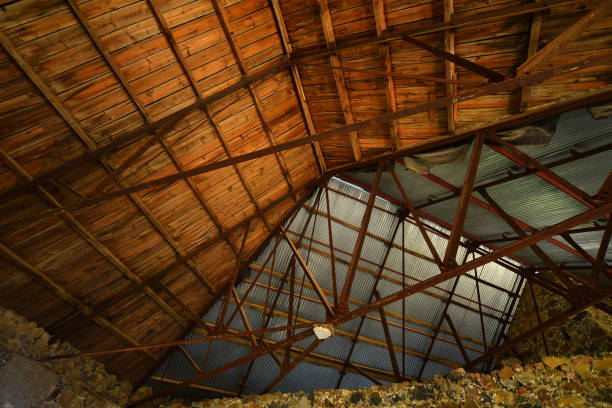 istock Vertical view in dark stone building with angled roof structures catching evening light 1283148669