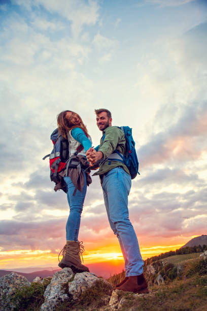 istock Couple on Top of a Mountain Shaking Raised Hands 1283148672