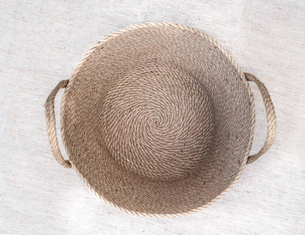 Empty round jute basket on linen tablecloth