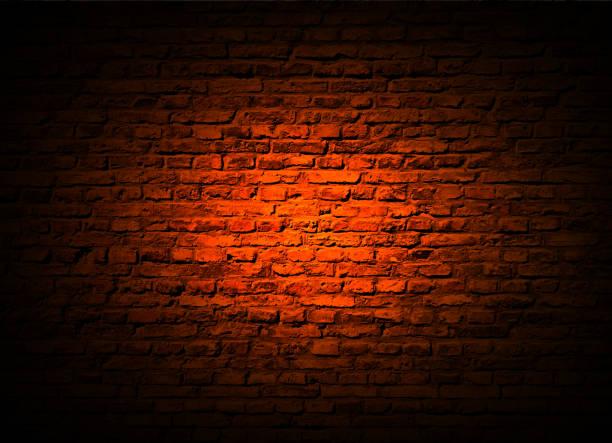 istock Abstract dark  brick wall background illuminated by a spot 1283149545