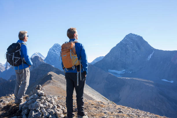 They chat and look off to distant Canadian Rocky Mountains