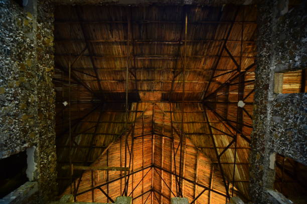 istock Vertical view in dark stone building with angled roof structure catching evening light 1283149728