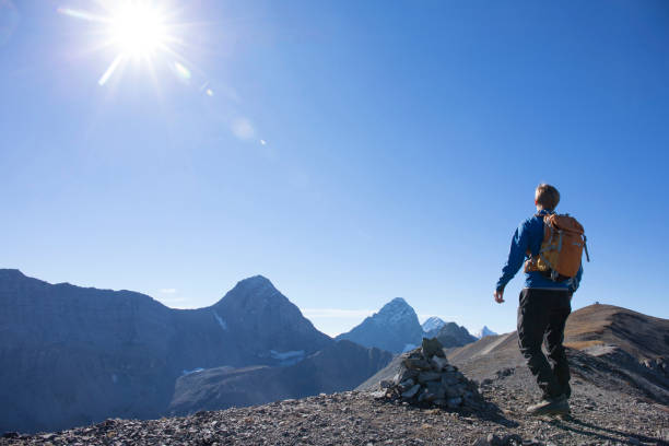 istock Young man hikes along mountain ridge in the morning 1283149863