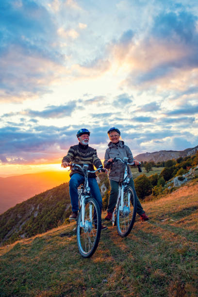 istock Active Senior Couple Riding Bikes In Park 1283150290