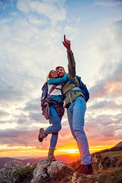 istock Couple on Top of a Mountain Shaking Raised Hands 1283151927