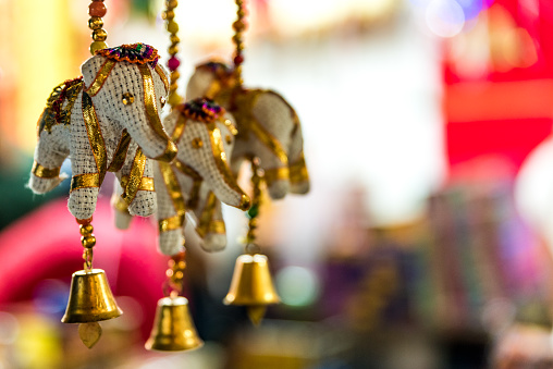 Handmade colorful elephant figurines, diwali or deepavali decor on green background. Traditional Indian door bells, hanging decoration