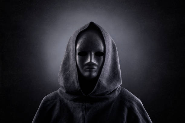 Portrait of a scary figure in hooded cloak Portrait of a scary figure in hooded cloak ceremonial robe stock pictures, royalty-free photos & images