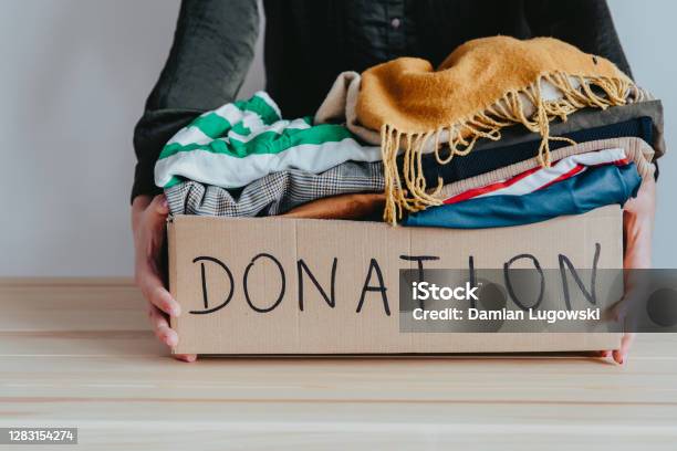 Woman Holding Cardboard Donation Box Full With Folded Clothes Stock Photo - Download Image Now