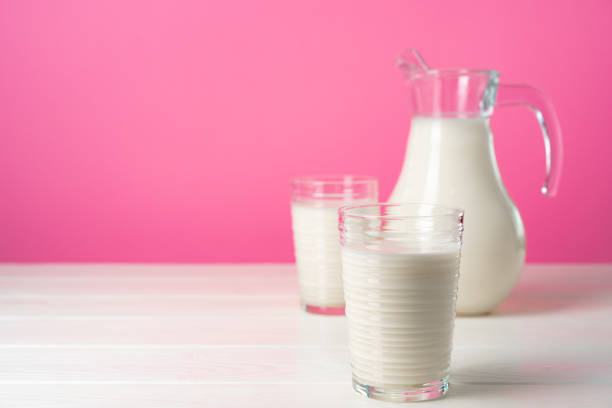 istock Glassware with fresh milk against pink pastel background 1283154426