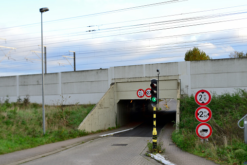 Herent, Vlaams-Brabant, Belgium - October 30, 2020: Single road-track cars tunnel under railway track. Green traffic light. Small road, only one lane. Switch directions passage cars.