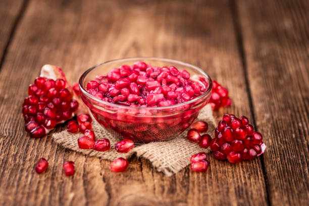 istock Old wooden table with fresh preserved Pomegranate seeds (close-up shot; selective focus) 1283155266