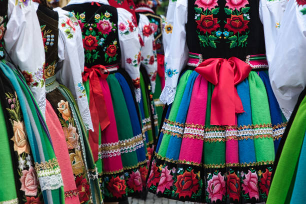 Women dressed in polish national folk costumes from Lowicz region Women dressed in polish national folk costumes from Lowicz region during annual Corpus Christi procession. Close up of traditional colorful striped Lowicz folk skirts and embroidery folk stock pictures, royalty-free photos & images