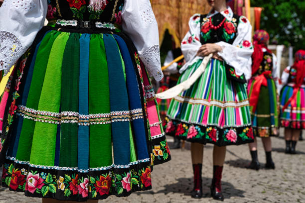 Women dressed in polish national folk costumes from Lowicz region Women dressed in polish national folk costumes from Lowicz region during annual Corpus Christi procession. Close up of traditional colorful striped Lowicz folk skirts and embroidery slavic culture photos stock pictures, royalty-free photos & images