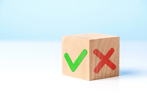 Wooden block with check mark and X. Choice and decision making concept