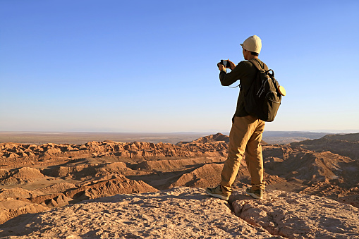 Traveler Shooting Photos on the Rocky Cliff of Valle de la Luna or the Moon Valley in Atacama Desert, San Pedro de Atacama, Northern Chile