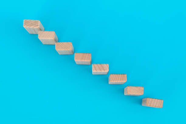 istock Wooden blocks as a staircase on blue background 1283155972
