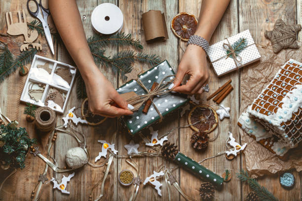 istock Young woman wrapping and decorates christmas present on table wi 1283155989