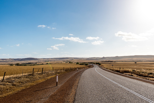 Long winding road in Australia. Empty highway in the middle of rural areas of Western Australia. Road through the Australian outback.